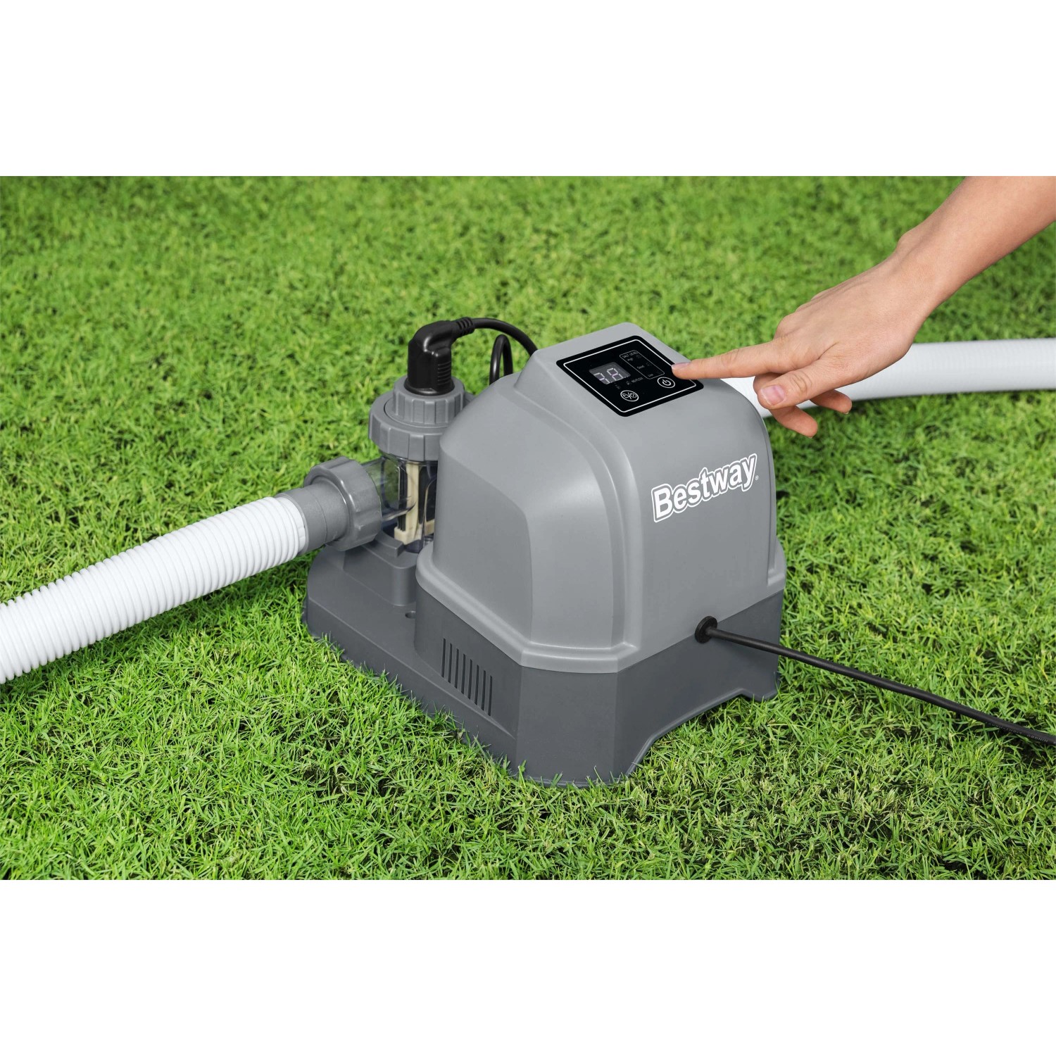 Sistema di trattamento acqua piscina Bestway su erba con mano sul pannello di controllo.