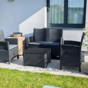 Set di mobili da giardino in rattan nero con divano, poltrone e tavolo.