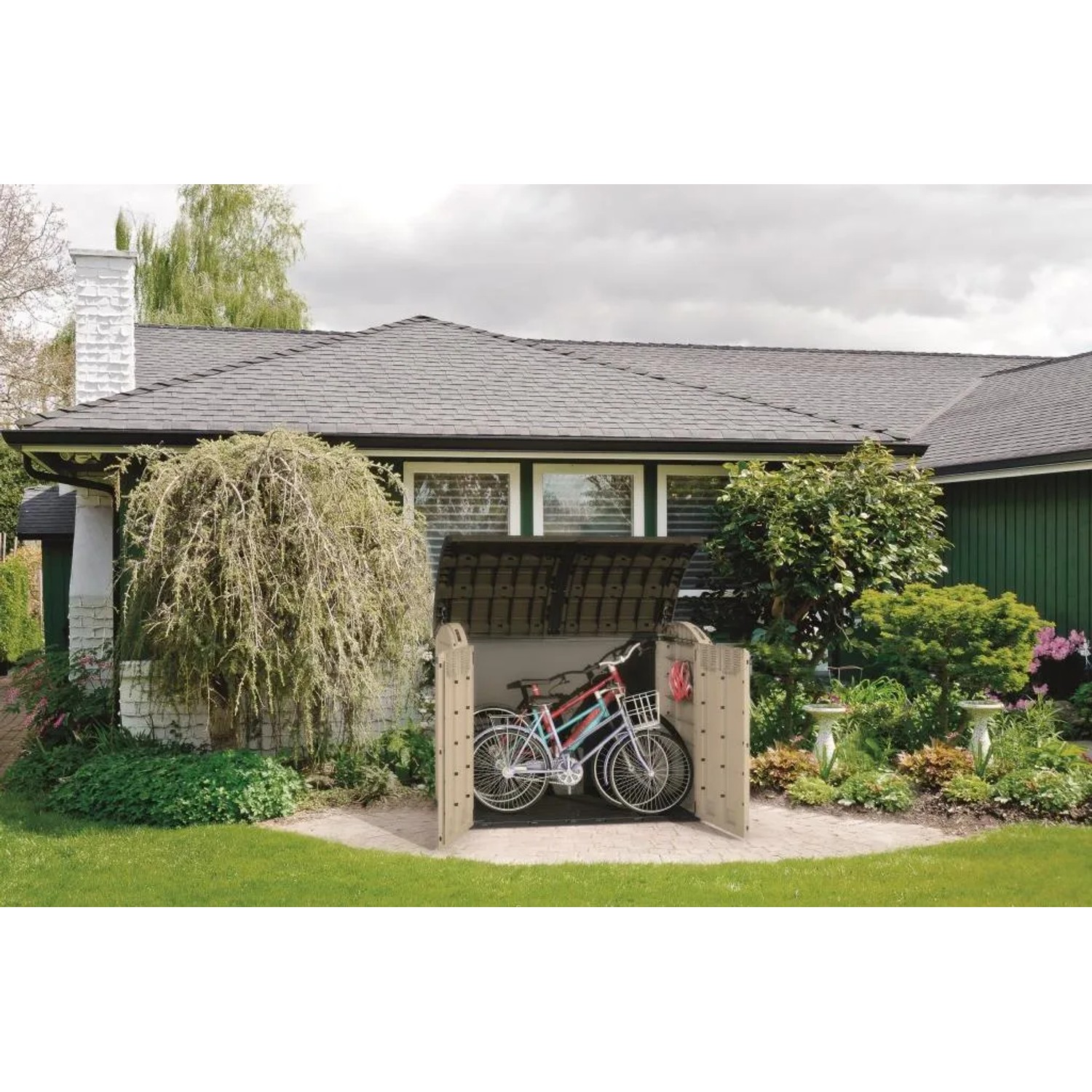 Box da esterno Keter Store It Out Ultra, beige/marrone, con biciclette in giardino.