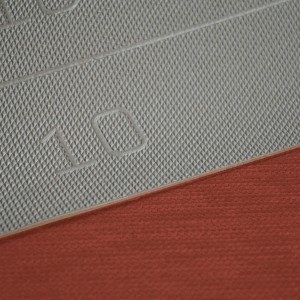 Dettaglio di un tappeto da cucina t.b.t. grigio con fondo rosso.