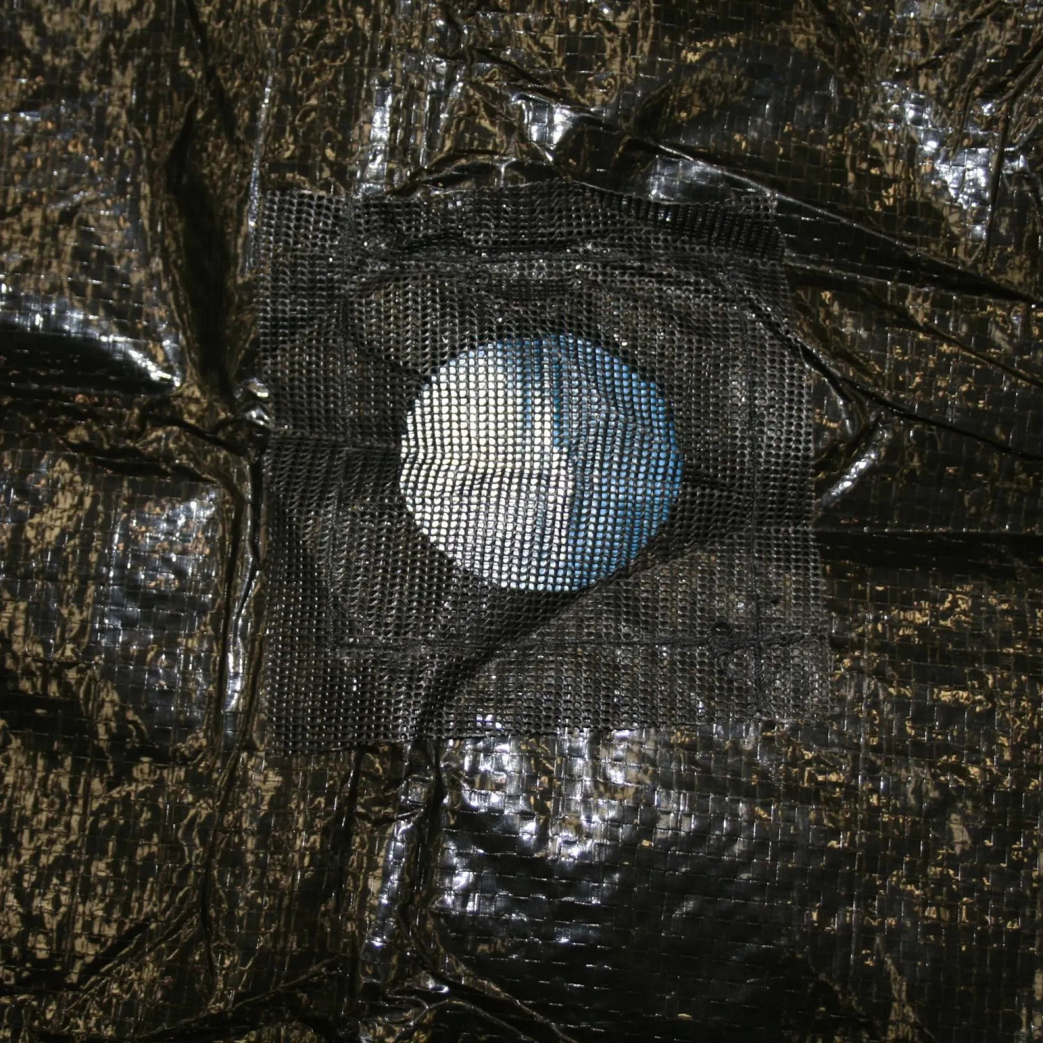 Dettaglio di una copertura invernale nera con finestra a rete.
