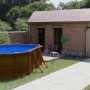 Piscina ovale Gre Pool Sicilia effetto legno, 500x300x120 cm, con scaletta in giardino.