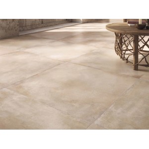 Piastrelle per pavimenti beige posate in interni, con tavolo sullo sfondo.
