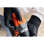 Primo piano di un avvitatore a batteria t.b.t. in azione, tenuto da mani con guanti.