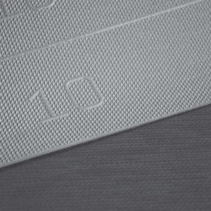 Dettaglio di un tappeto da cucina t.b.t. grigio con motivo a rombi e il numero 10.