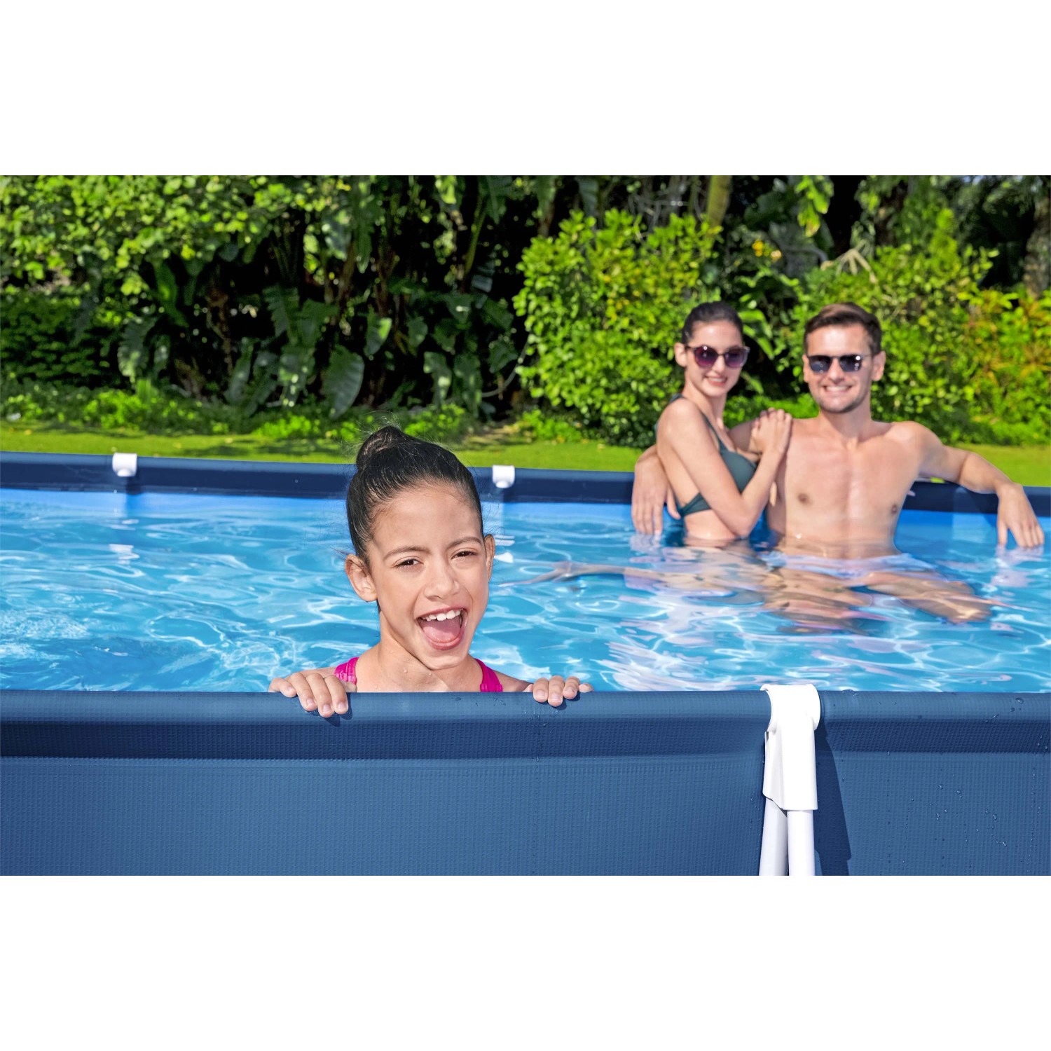 Famiglia nella piscina t.b.t.. Piscina fuori terra con struttura blu e acqua limpida.