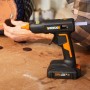 Pistola per colla a caldo a batteria Worx che applica cuscinetti in feltro.