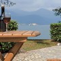 Tavolo da giardino in legno con vino e vista lago. Ideale per rilassarsi all'aperto.