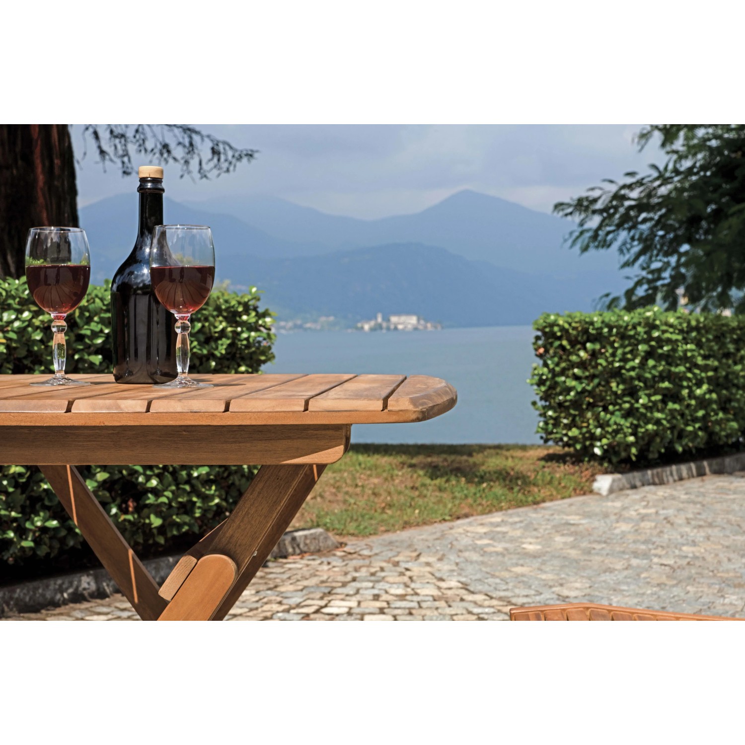 Tavolo da giardino in legno con vino e vista lago. Ideale per rilassarsi all'aperto.
