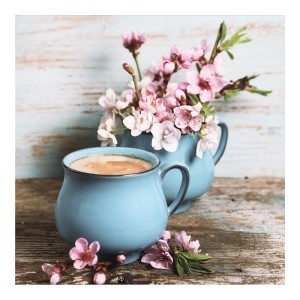 Tazza Quadri blu con bevanda e fiori rosa su legno.