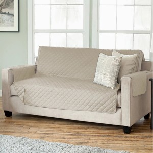 Copridivano trapuntato beige di t.b.t. con braccioli e cuscini.