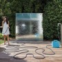 Donna che annaffia le piante con un tubo per irrigazione t.b.t. in giardino.