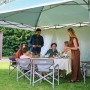 Coleman FastPitch OnePush Shelter L verde e bianco in campeggio con persone.