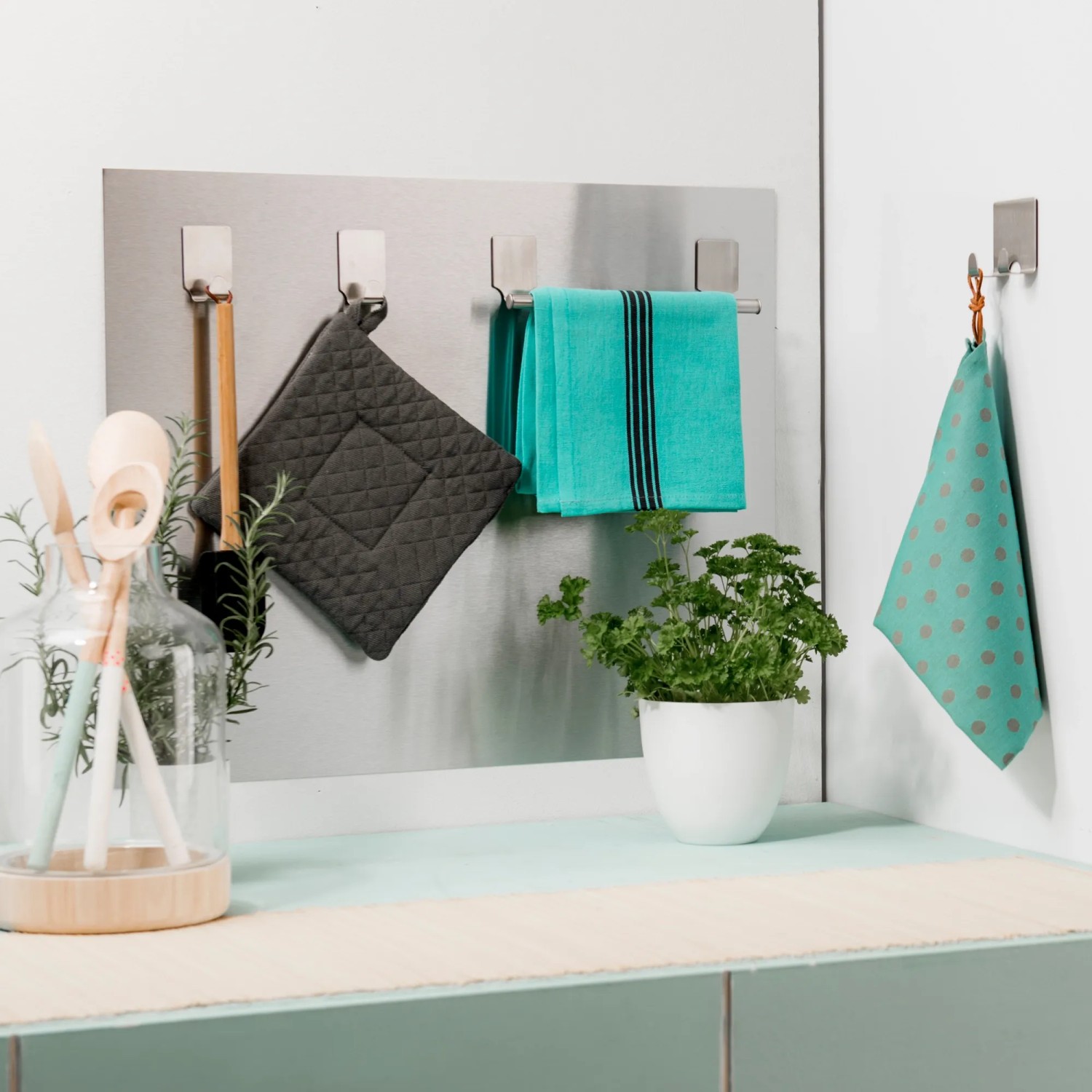 Utensili da cucina e tessili su un supporto a parete per cucina. Utensili da cucina e strofinacci.