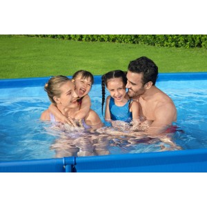 Famiglia che si diverte in una piscina t.b.t blu. Piscina fuori terra per divertirsi in giardino.