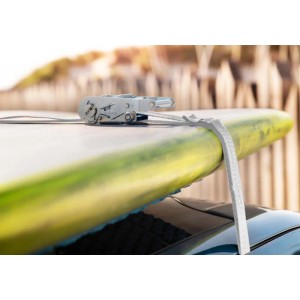 Cinghia di fissaggio t.b.t. che assicura un carico, qui una tavola da surf sul tetto di un'auto.