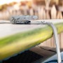 Cinghia di fissaggio t.b.t. che assicura un carico, qui una tavola da surf sul tetto di un'auto.