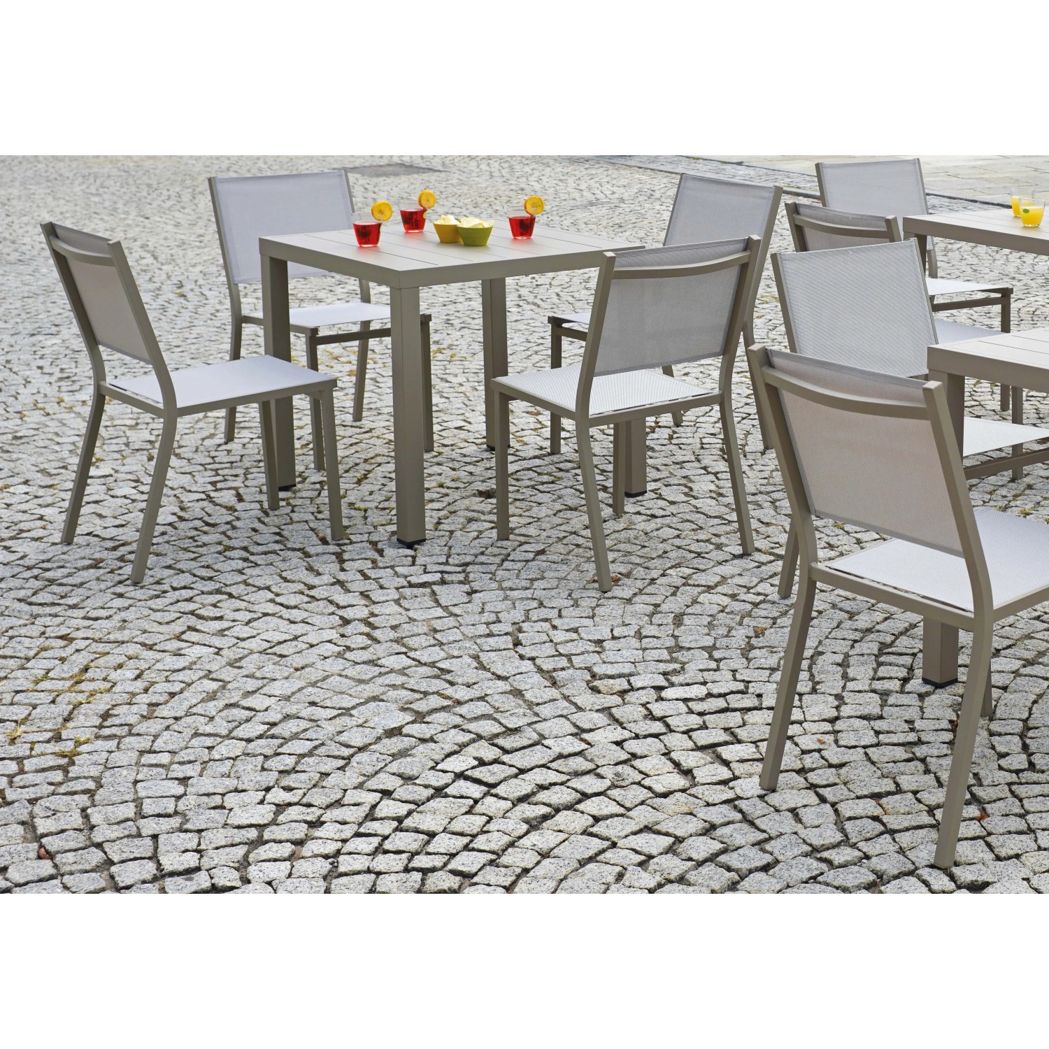 Set da pranzo per giardino: tavolo e sedie in metallo grigio.