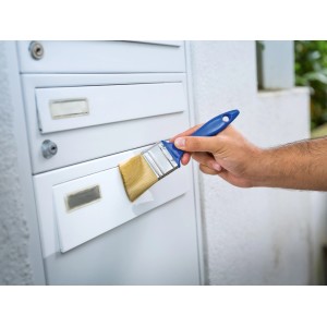 Mano che dipinge cassetta postale con set di pennelli piatti LUX, 3 pezzi. Pennello con manico blu.