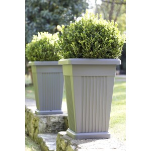 Vasi per piante grigi t.b.t. in plastica con piante in giardino.