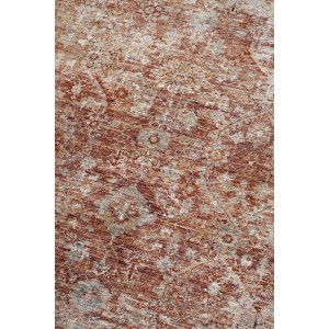 Dettaglio di un tappeto vintage a motivi nei toni del rosso e del beige.