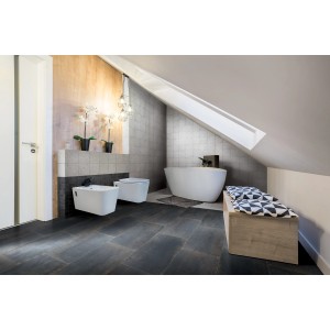 Bagno con piastrelle da rivestimento t.b.t grigie, pavimento scuro e vasca freestanding.