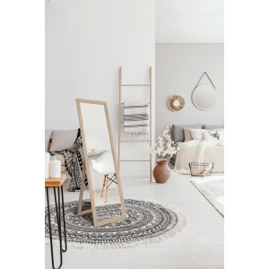 Specchio da parete autoportante con cornice in legno in camera da letto su tappeto rotondo.