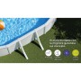 Piscina ovale fuori terra Gre bianca in giardino con acqua blu e supporti. Robusta piscina con pareti in acciaio.