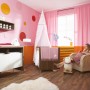 Pavimento in laminato Comfort Noce Naturale Opaco Scuro installato in una cameretta rosa.