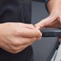 Mani che collegano un dispositivo t.b.t., accessorio per abbigliamento da lavoro.