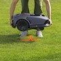 Robot tagliaerba t.b.t. trasportato da una persona sull'erba.