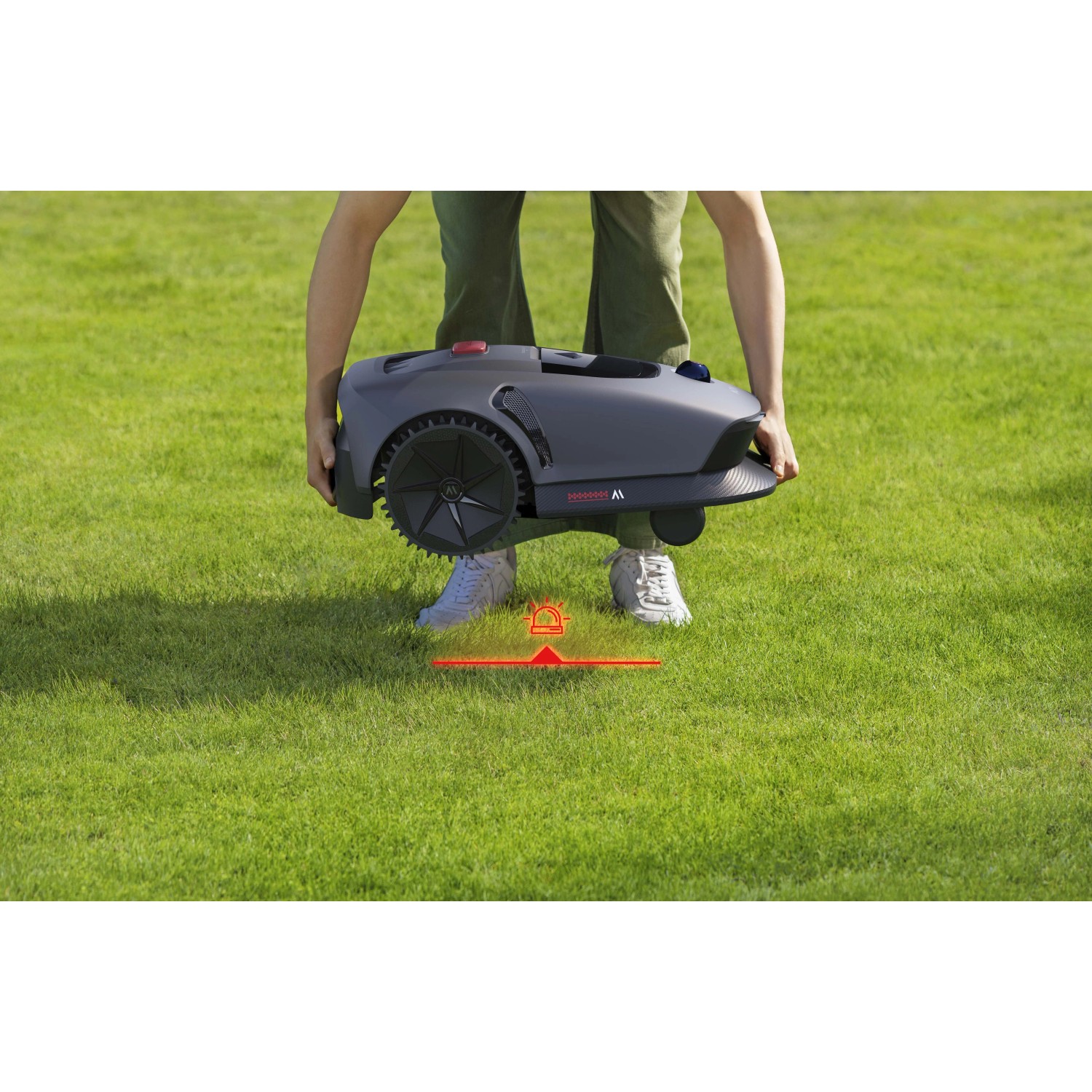 Robot tagliaerba t.b.t. trasportato da una persona sull'erba.