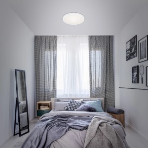 Plafoniera LED t.b.t. in una camera da letto con letto e tende.