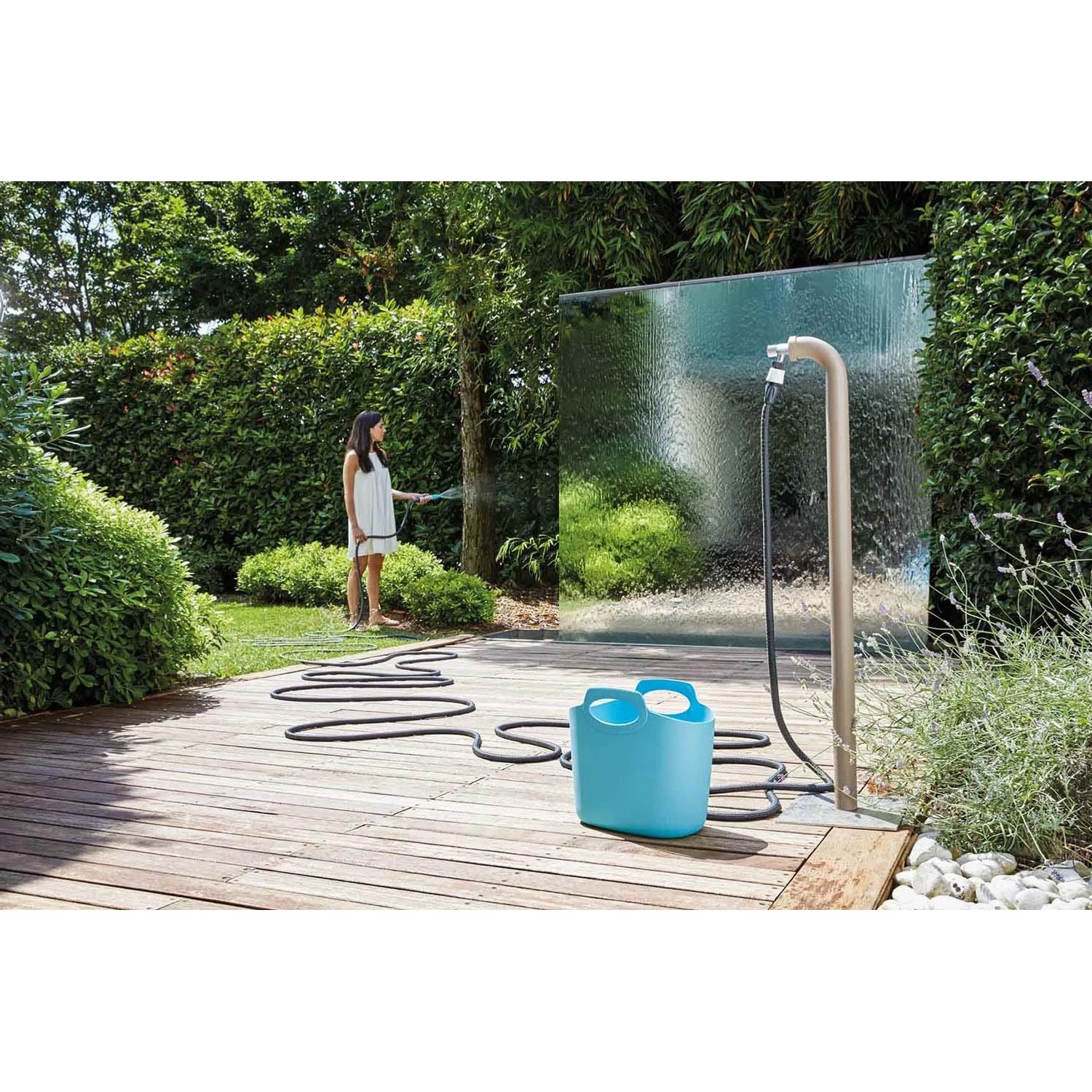 Sistema di irrigazione t.b.t. con tubo e cesto di stoccaggio in giardino.