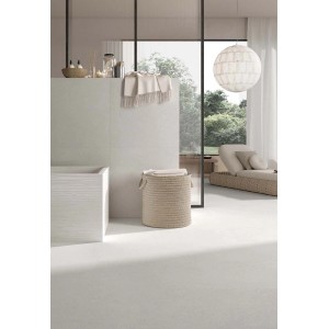 Bagno luminoso con piastrelle per pavimenti t.b.t., vasca e cesto della biancheria.