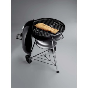 Weber barbecue a carbone Compact Kettle, 57 cm, nero, con pesce sulla griglia.