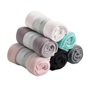 Coperte/plaid t.b.t. arrotolate e impilate in vari colori.