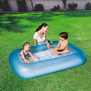 Piscina gonfiabile blu in giardino con bambini e madre che giocano.