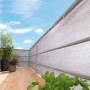Schermo per balcone grigio 90x500 cm come protezione da vento e sguardi indiscreti su un balcone con piante e mobili.