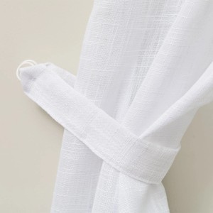 Dettaglio di una tenda in tessuto t.b.t. bianca con embrasse coordinato.