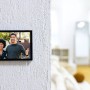 Videocitofono Ezviz HP7 con due persone davanti alla telecamera su una parete.