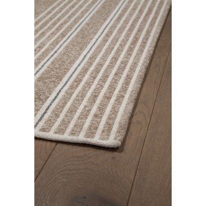 Dettaglio di un tappeto moderno a righe beige e bianco.
