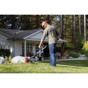 Uomo che usa un tagliabordi a batteria t.b.t. in giardino.