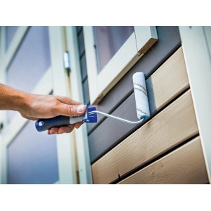 Mano che dipinge facciata in legno con rullo per velature LUX (10 cm). Set di rulli per pittura con nylon per velature e vernici.