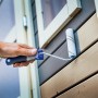 Mano che dipinge facciata in legno con rullo per velature LUX (10 cm). Set di rulli per pittura con nylon per velature e vernici.