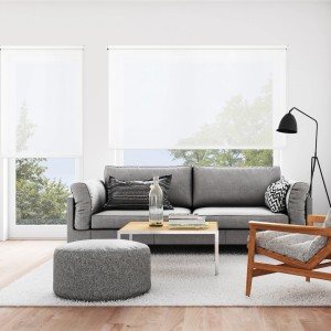 Tende a rullo t.b.t. chiare in un moderno soggiorno con divano e finestra.