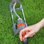 Irrigatore da giardino con raccordo per l'acqua in uso su prato.