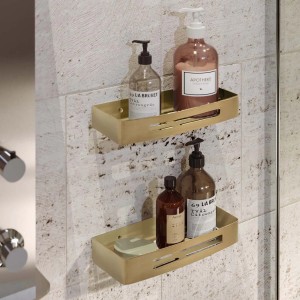 Due mensole a muro dorate con saponi e lozioni nel bagno. Accessori da parete.