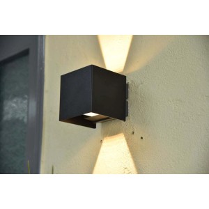 Moderna applique da esterno t.b.t. nera a forma di cubo su una parete.