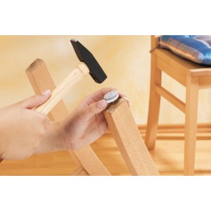 Feltrini fissati a una gamba di sedia con un martello.